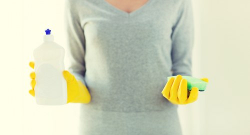 Professional cleaner introducing Sutton cleaning services in a local home setting